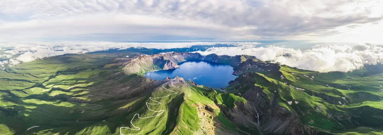 新华社照片，长春，2024年6月8日
       （新华全媒头条&middot;图文互动）长白天地宽&mdash;&mdash;一座山的区域旅游发展实践
       这是夏日长白山天池景色（资料照片）。
       配发本社同题文字稿。
       新华社发（卓永生摄）  通联记者电话：18686602343  签发人：段续