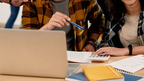 Multi-ethnic group of university students communicating and having fun while learning together in the classroom.